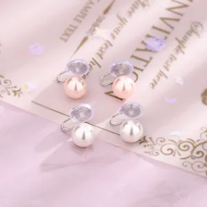 Dettaglio di eleganti orecchini a clip con perle tonde rosa e bianche per lobi non forati