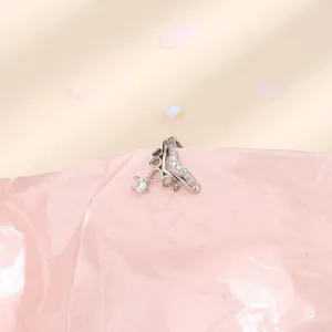 Dettaglio macro di un orecchino a clip a corona a V in argento con zirconi.