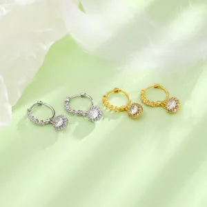Détail de boucles d'oreilles créoles avec pendentif étincelant en zircon argent et or