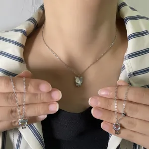 Close-up of cute cat pendant necklace with colorful moonstone inlay and silver chain