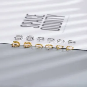 Dettaglio di orecchini a cerchio in zircone argento e oro con ciondoli a triangolo per set