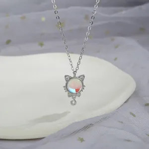Detailed macro shot of a silver cat pendant with a colorful iridescent moonstone