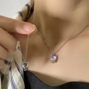 Close-up detail of silver cat pendant necklace with iridescent stone and rhinestones
