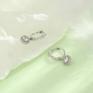 Détail de boucles d'oreilles créoles argentées élégantes avec breloques en zircone