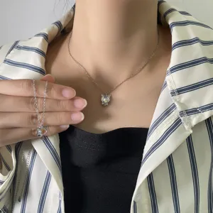 Close-up view of a cute silver cat pendant necklace with moonstone worn by a model