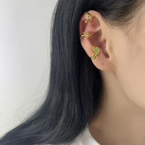 Elegante set di ear cuff dorati con insetti e zirconi indossati da una modella