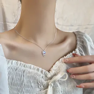 Close-up view of a minimalist silver cat pendant necklace with colorful moonstone gem