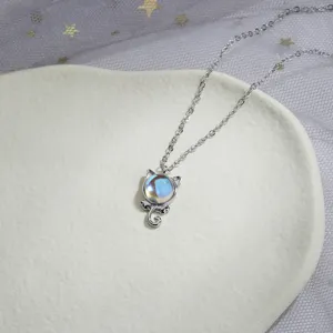 Close-up of cute cat pendant necklace featuring an iridescent moonstone orb in silver.