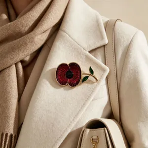 Close-up of elegant red poppy enamel brooch pinned on a stylish beige wool coat lapel