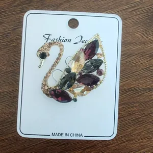 Detail view of a vintage swan brooch with colorful marquise rhinestones on a card