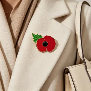 Primer plano de elegante broche de esmalte amapola roja en un abrigo