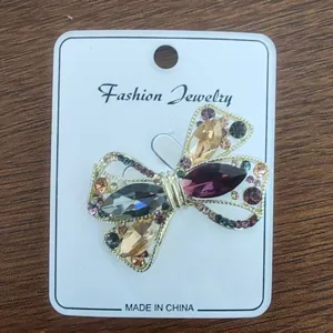 Close-up of elegant bow brooch featuring multicolored rhinestones on a gold-tone alloy base