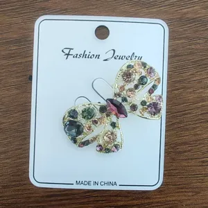 Detail of vintage butterfly brooch pin with multicolored crystals on a card
