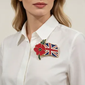 Detailweergave van een emaille rode klaproos en Britse vlag broche op een wit shirt.