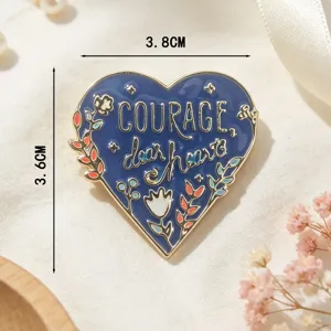 Blauer Emaille-Herz-Anstecker mit 'COURAGE, dear heart' Text und 3,8x3,6 cm Maßen