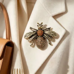 Vista detallada de un broche de abeja retro con diamantes de imitación en un abrigo blanco