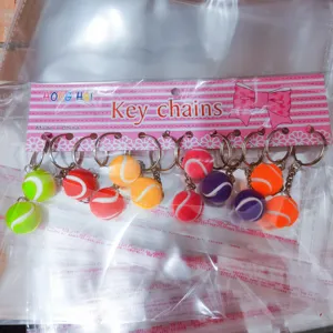 Detailopname van diverse kleurrijke 2cm mini tennisbal sleutelhangers in handelsverpakking
