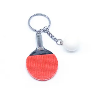 Gedetailleerde macro-weergave van de mini pingpong bat en bal sleutelhanger in rood