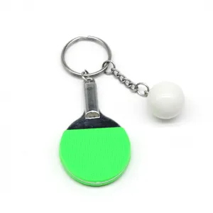 Gedetailleerde weergave van een mini groene pingpongbatje sleutelhanger met wit balletje