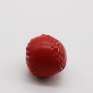 Detailed close-up view of a red leather mini baseball accessory with white stitching