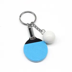 Gedetailleerd beeld van een mini blauwe tafeltennisbatje en bal aan een zilveren sleutelhanger
