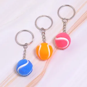 Gedetailleerde weergave van 2 cm mini tennisbal sleutelhangers in blauw, oranje en roze.