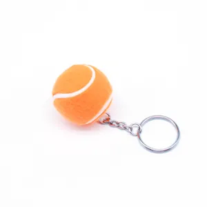 Vista detallada de un mini llavero de pelota de tenis naranja con un aro plateado.