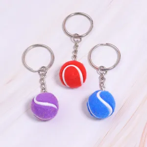 Gedetailleerde weergave van drie kleurrijke 2cm mini tennisbal sleutelhangers.