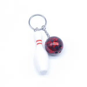 Gedetailleerde weergave van kegel- en bowlingbal-sleutelhanger op witte achtergrond