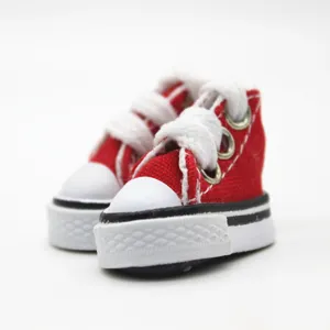 Macro detail of 3.5cm mini red canvas sneakers for dolls with white laces and rubber sole