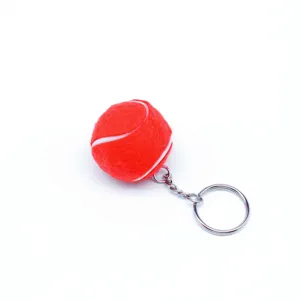 Vista macro de un mini llavero de pelota de tenis roja con textura de fieltro y aro