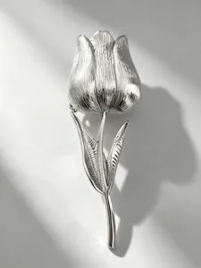 Dettaglio spilla a forma di tulipano argento con finitura metallica strutturata per abiti