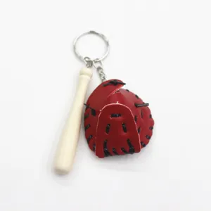 Detailopname van een creatieve sleutelhanger met rode honkbalhandschoen en knuppel.