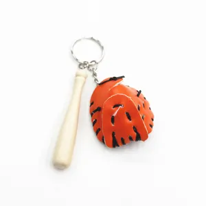 Gedetailleerde weergave van een miniatuur oranje honkbalhandschoen en houten knuppel hanger