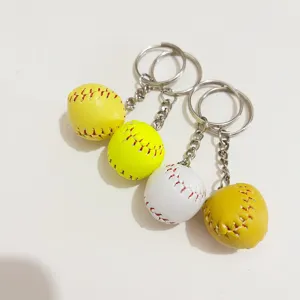 Close-up of 2cm mini baseball keychains in yellow and white with realistic stitching