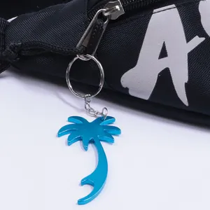 Primer plano de llavero abridor de botellas de palmera azul colgado en la cremallera de mochila.