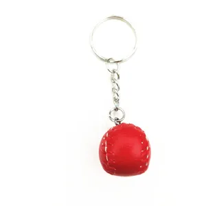Close-up detail of a red mini baseball keychain with white stitching and silver ring
