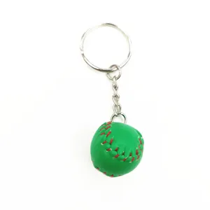 Close-up of a mini green baseball keychain with red stitching on a white background