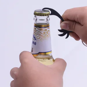 Vista detallada de un llavero abrebotellas negro con forma de palmera en uso
