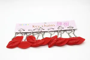 Pack of ten glossy red resin lip shaped keychains on a branded display card accessory