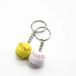 Close-up of mini 2cm yellow and white baseball keychains with red stitching details