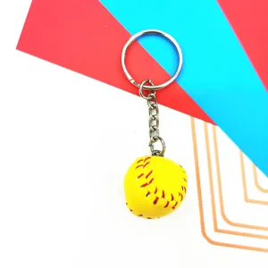 Close-up of mini yellow baseball keychain with detailed red stitching and silver ring.