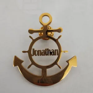 Close-up of golden anchor brooch with personalized Jonathan name cutout