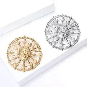 Detalle exquisito de los broches celestiales de sol y luna en acabados oro y plata.