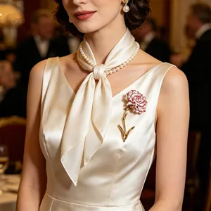 Close-up of an elegant red and white enamel carnation brooch on a satin dress