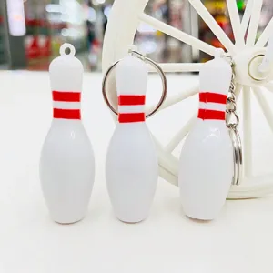 Gedetailleerde weergave van witte miniatuur bowlingpin sleutelhangers met rode strepen