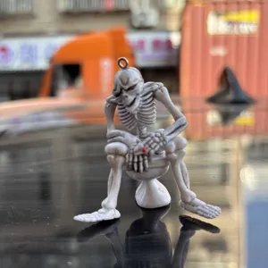 Detailed view of funny skeleton figurine sitting on a white toilet keychain