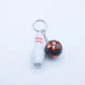 Detail view of creative mini bowling keychain featuring a white pin and black patterned ball