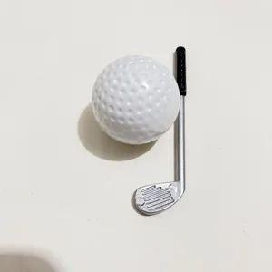 Detailed macro shot of mini white golf ball and silver golf club accessory