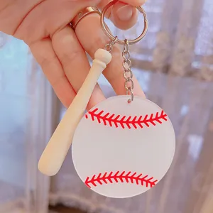 Close-up of acrylic baseball keychain with mini wooden bat and red stitching detail.